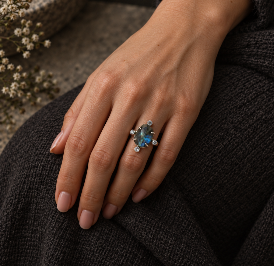Labradorite quartz ring with an oval blue stone and quartz accents, shown on a model’s hand