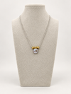 Silver coin pearl necklace displayed on a jewelry bust