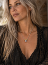 Silver coin pearl necklace with a round pendant worn by a model